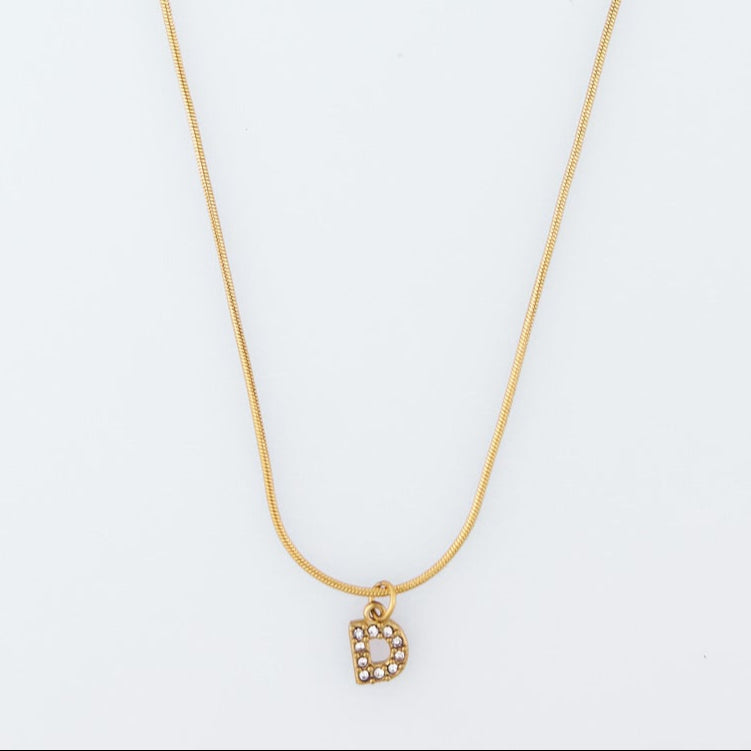 Gold necklace with a small pendant on a white background