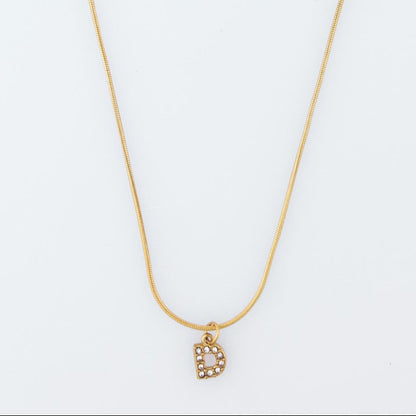Gold necklace with a small pendant on a white background