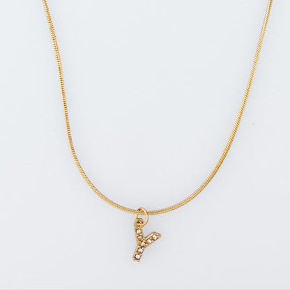 Gold necklace with a 'V' pendant on a light gray background